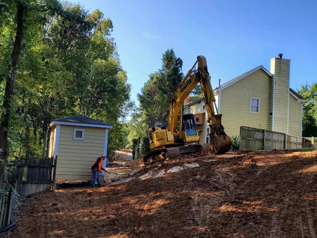 excavator ready for digging between tow houses
